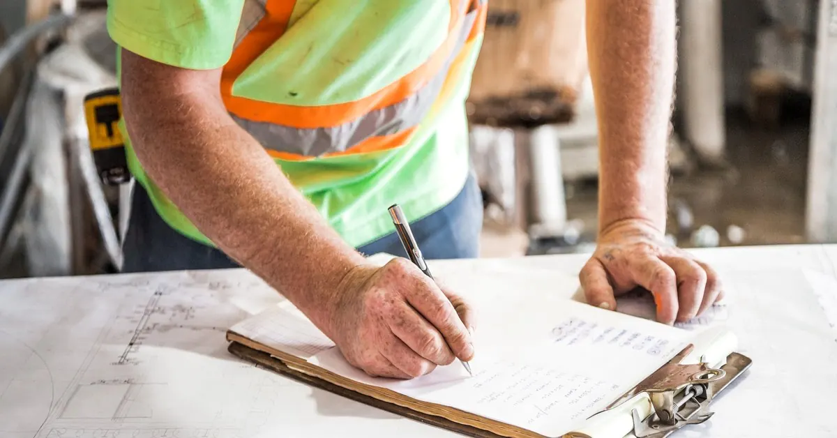 Responsable chantier renseignant une checklist de prévention sur un clipboard.
